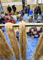 Sumo wrestlers prepare new rope for new yokozuna Kisenosato