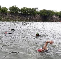 Triathletes swim in Osaka castle moat