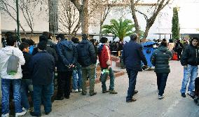People line up for free meals in Athens