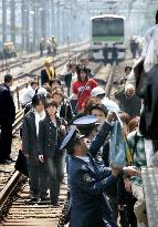 Tokyo trains halted, more than 1,000 walk on tracks to station