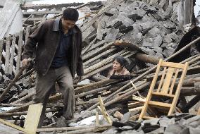 China earthquake -- searching for valuables in destroyed house