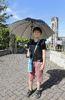 School student with umbrella in the sun
