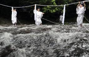 Sacred rope exchange event at western Japan waterfall