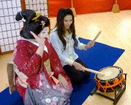 Vacationers enjoying lessons from geisha