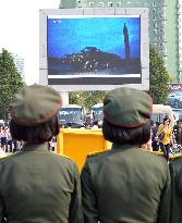 North Koreans watch news of their country's missile launch