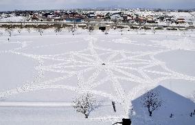 Geometric pattern drawn on snow-covered rice field