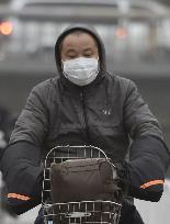 Man wears mask in hazy Beijing