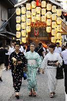 Women clad in "yukata" enjoy float parade at Kyoto summer festival