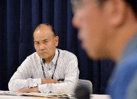 Fukushima fishery leader listens to utility official with stern face