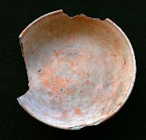 Ancient clay pot shown with drawing similar to traditional Korean game pattern