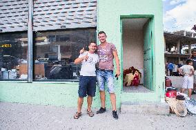 Korce (Korca) town, two young men pose in front of their shop