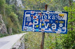 the Piva River sign covered with stickers