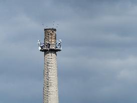 Factory chimney, antennas, stairs, people