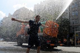 tank truck sprinkles by water the Wenceslas Square in Prague, man