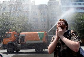 tank truck sprinkles by water the Wenceslas Square in Prague, man