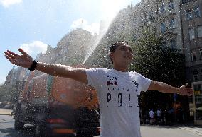 tank truck sprinkles by water the Wenceslas Square in Prague, man