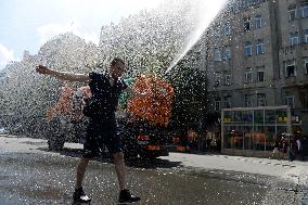 tank truck sprinkles by water the Wenceslas Square in Prague, man