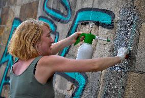 removal graffiti from sprayed pillar of Prague's historical Charles Bridge