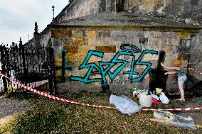 removal graffiti from sprayed pillar of Prague's historical Charles Bridge