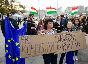 A woman holding a poster with writing FREE KURDISTAN