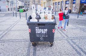garbage container full of waste and busts of Jan Hamacek, PM Andrej Babis and Richard Brabec, Heritage or Waste campaign