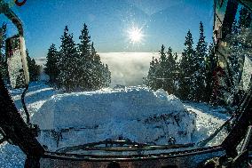 snowcat moves snow in ski resort, sun