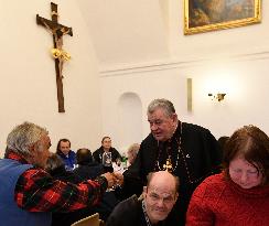 Prague archbishop Dominik Duka dining with homeless at Christmas