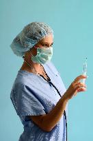 nurse with a medical cap, mask, stethoscope and injection