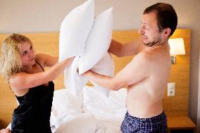 young couple in the bed, man, woman, pillow battle
