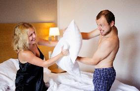 young couple in the bed, man, woman, pillow battle