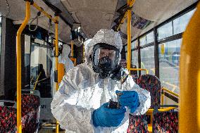 a worker with ozone disinfects a public bus against coronavirus