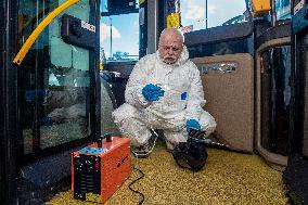 a worker with ozone disinfects a public bus against coronavirus