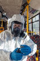 a worker with ozone disinfects a public bus against coronavirus