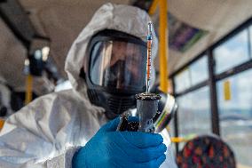 a worker with ozone disinfects a public bus against coronavirus