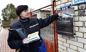 a postwoman distributes information flyers about the novel coronavirus