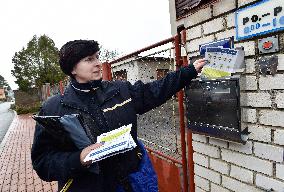 a postwoman distributes information flyers about the novel coronavirus