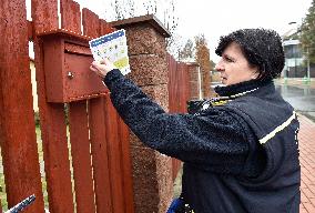 a postwoman distributes information flyers about the novel coronavirus