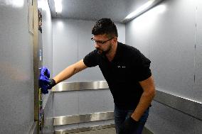 a worker disinfects public interior parts at the Gallery Santovka shopping mall against coronavirus, elevator