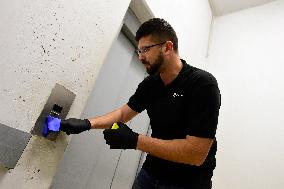 a worker disinfects public interior parts at the Gallery Santovka shopping mall against coronavirus, elevator