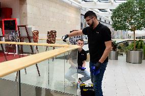 a worker disinfects public interior parts at the Gallery Santovka shopping mall against coronavirus