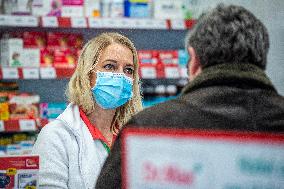 an apothecary serves a customer in a pharmacy