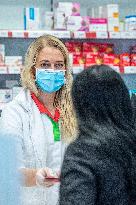 an apothecary serves a customer in a pharmacy