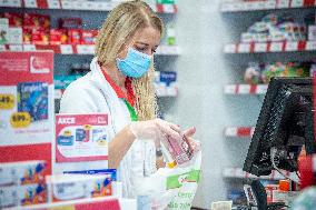 an apothecary serves a customer in a pharmacy