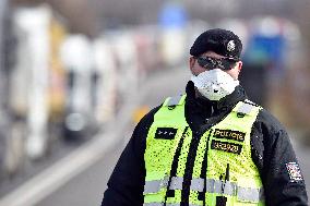 policeman, mask, control, traffic jam of trucks at the Bohumin - Chalupki crossing between Poland and the Czech Republic