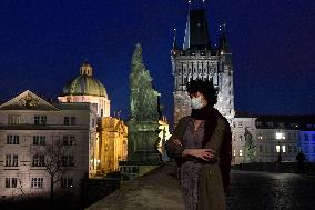 empty Charles Bridge, young woman wearing a face mask