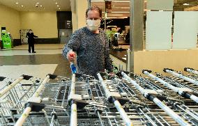 worker disinfects shopping carts against coronavirus, shop, grocery