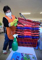 store manager disinfects shopping baskets against coronavirus, shop, grocery
