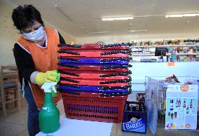 store manager disinfects shopping baskets against coronavirus, shop, grocery