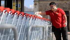 worker disinfects shopping carts against coronavirus, shop, grocery