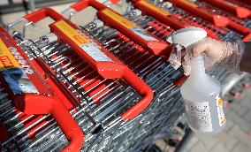 employee disinfects shopping carts against coronavirus, shop, grocery